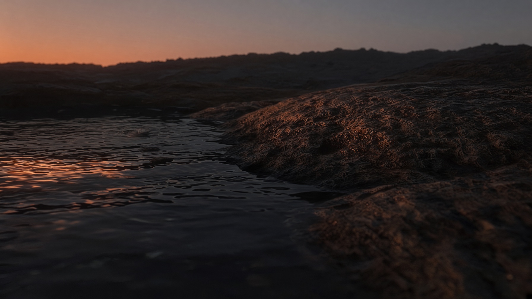 First terracotta light along dark water and skin-warm stone, close enough to feel like a body.
